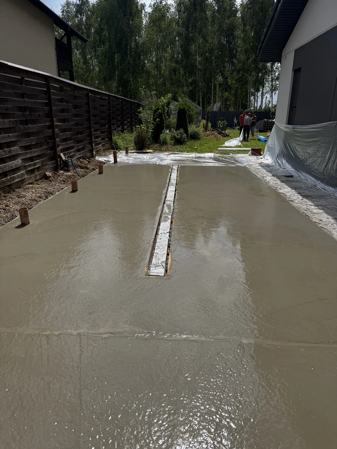 Свежезалитая бетонная парковка с линейным водоотводом